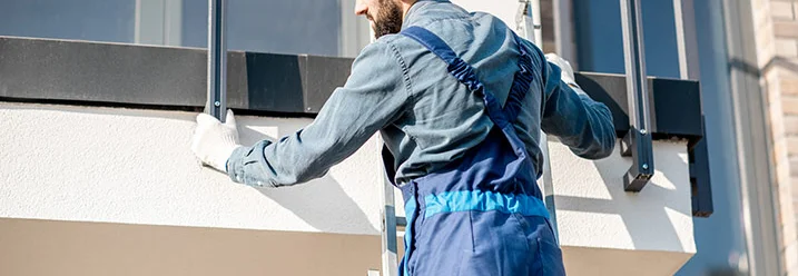 Person auf Leiter montiert Geländer